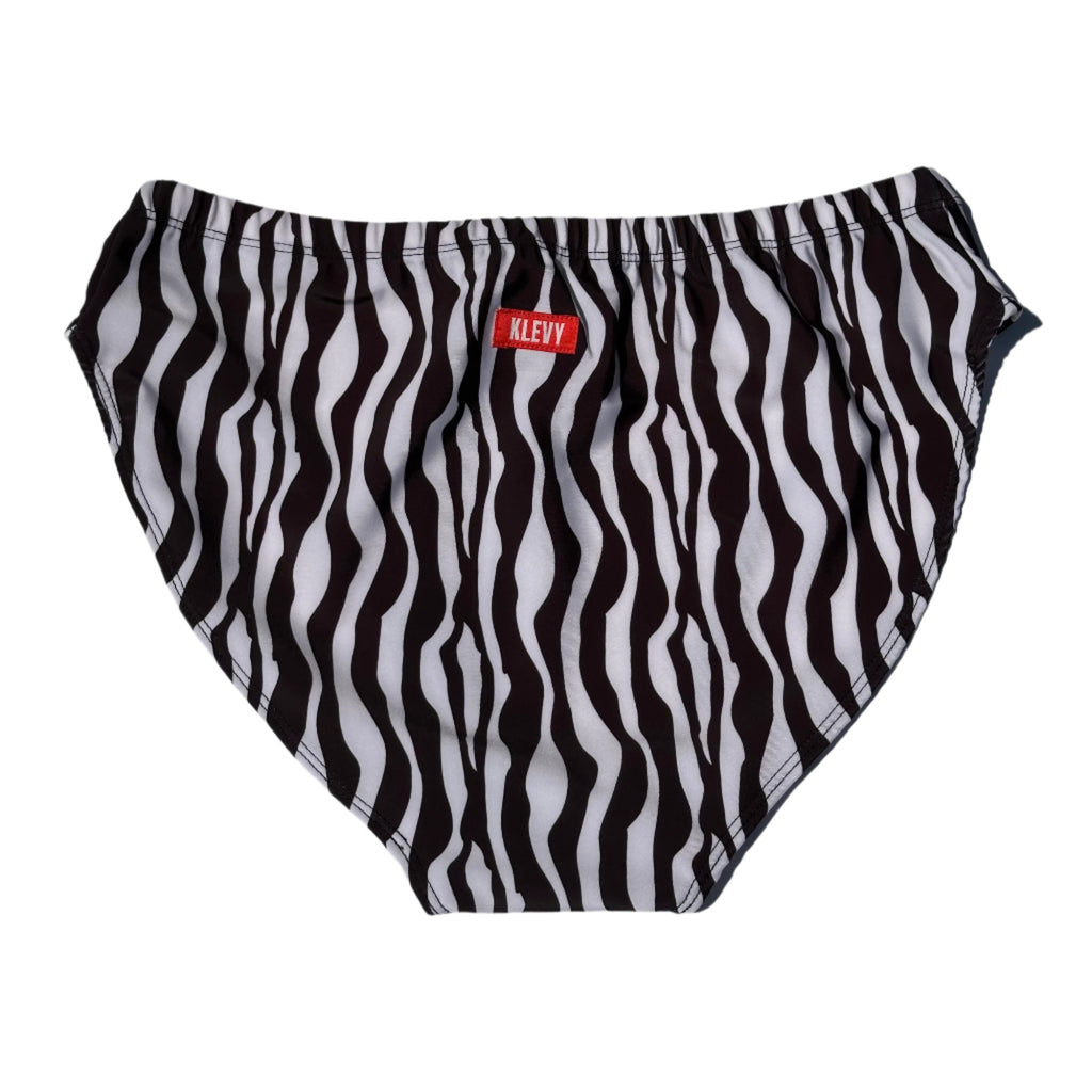 Black and white striped swim briefs with a visible brand label on a light gray background