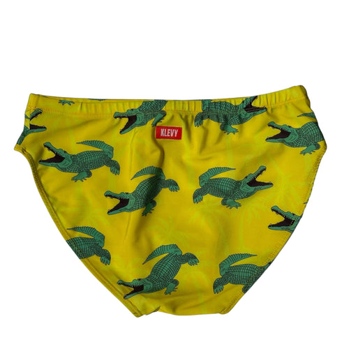 Yellow swim briefs with green crocodile pattern and Klevy brand label on a white background